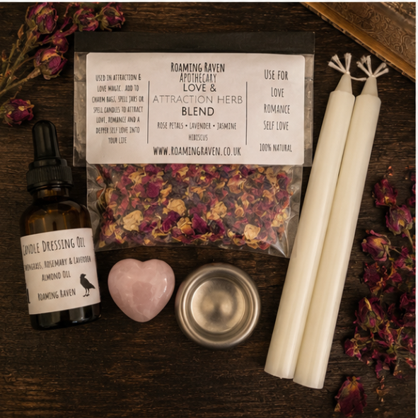 Open black presentation box displaying a handmade love spell kit with rose quartz crystal, herbal blend, candles, candle dressing oil and ritual instructions.