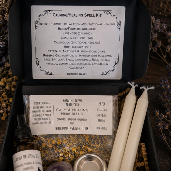 Close-up of healing spell kit contents including calming herb blend, herbal candle dressing oil, white spell candles, amethyst crystal and metal candle holder.