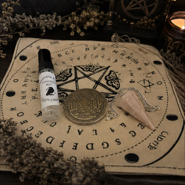 Complete witchcraft divination kit featuring a crystal pendulum, divination cloth, clairvoyant mist, yes and no decision coin and instruction cards on a mystical altar cloth.