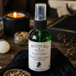 Protection Shield intention mist handcrafted with Cedarwood, Patchouli and Clove essential oils in a green glass spray bottle by Roaming Raven