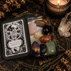 Wheel of the Year Gemstone Set in a black keepsake tin with eight polished Sabbat crystals displayed on a witchy altar.