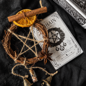 Samhain witches bells altar decoration with twig wreath, twine pentagram, cinnamon, orange and star anise