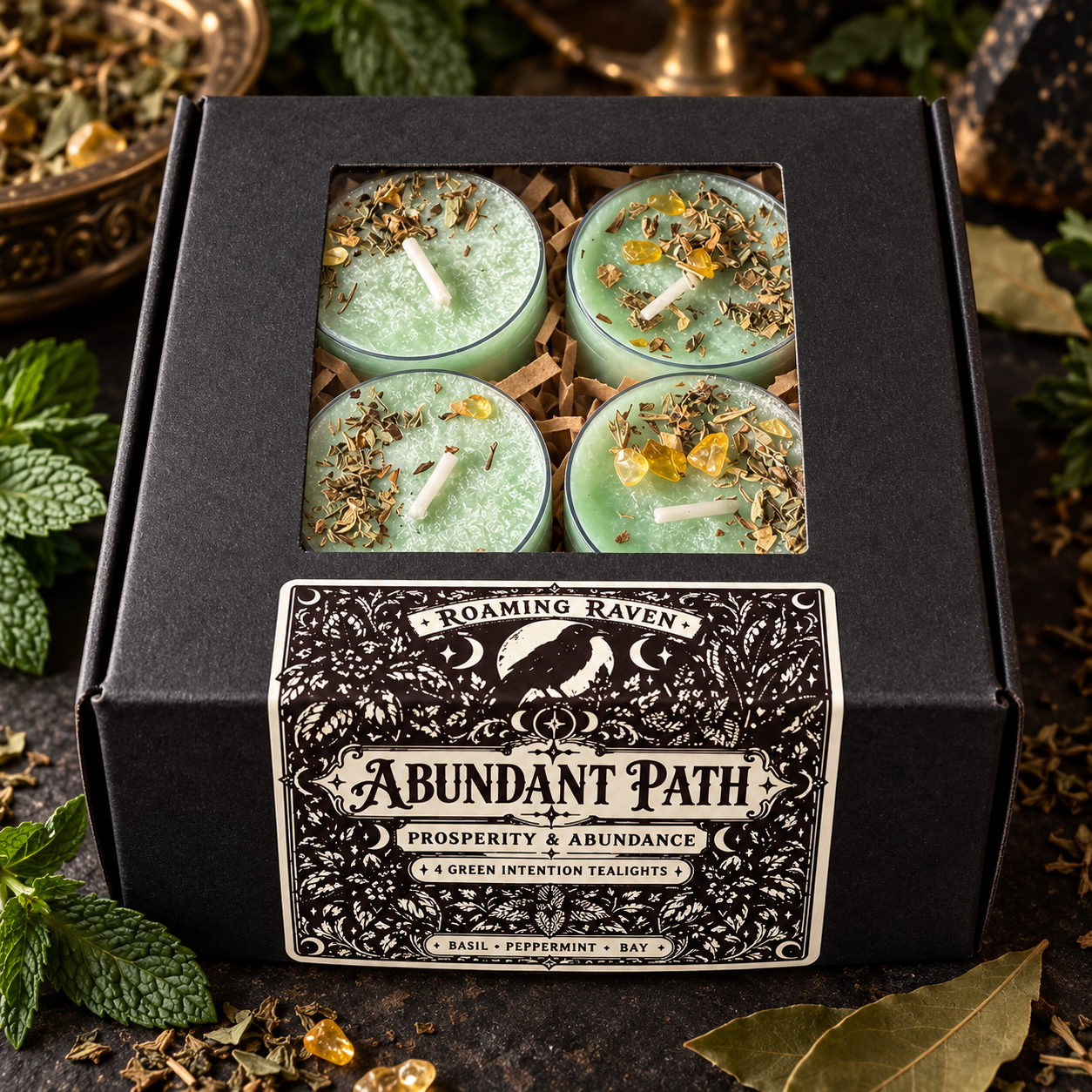 Overhead view of four green herbal tealights in an open black box beneath “Plant Your Intentions” lettering, framed by botanical and moon decorations.
